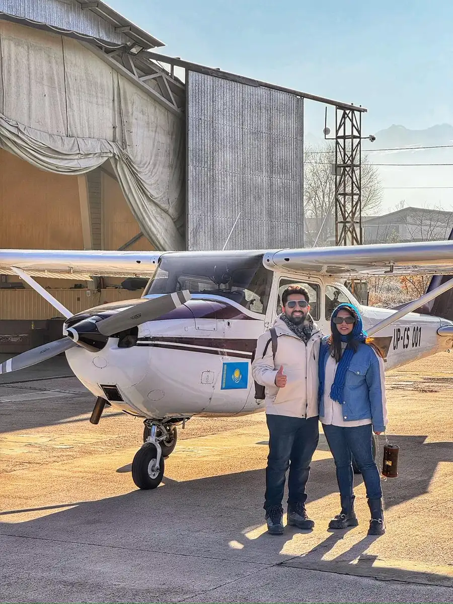 Couple posing in front of a Cessna aircraft after a flight near Almaty
